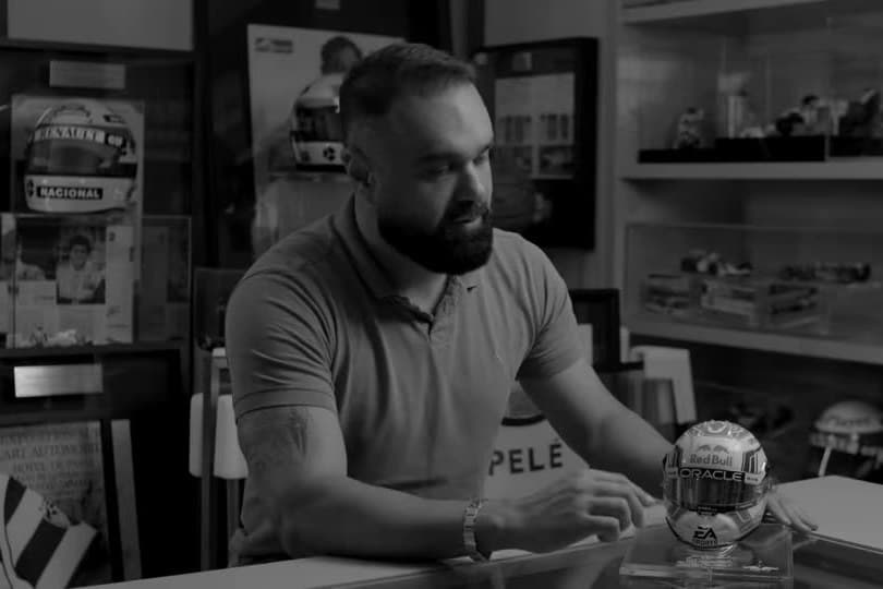 O fundador no balcão do acervo, com um capacete em caixa