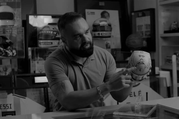O fundador com um capacete autografado, diante do acervo